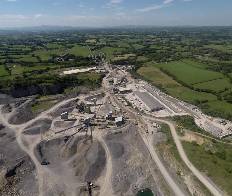 Aerial view of FP McCann's Clarke's Quarry and Precast Factory in Lisnaskea, County Fermanagh, showing various concrete products and aggregate stockpiles.